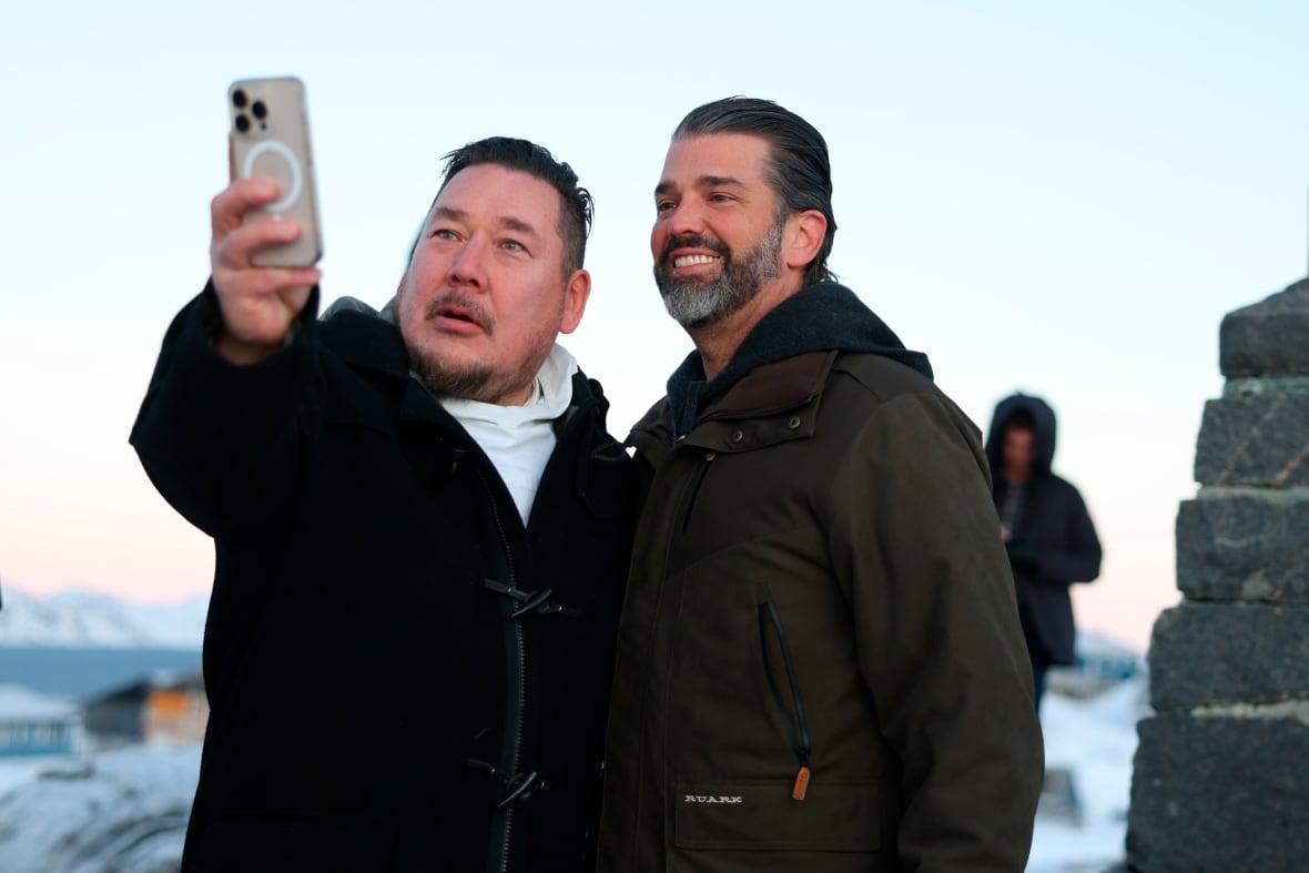 Two men pose for a selfie photograph