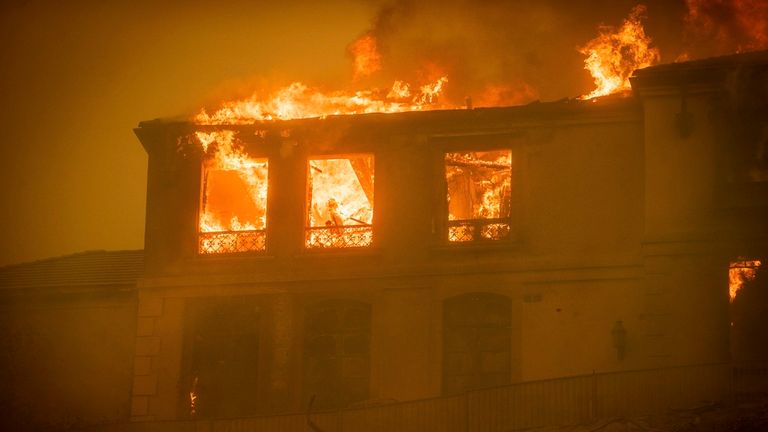 A residence burns as the Palisades Fire advances in the Pacific Palisades neighborhood of Los Angeles, Tuesday, Jan. 7, 2025. (AP Photo/Ethan Swope)