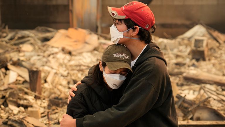 Ari Rivera, right, and Anderson Hao and woman hold each other in front of their destroyed home in Altadena, Calif., Thursday, Jan. 9, 2024. Pic: AP