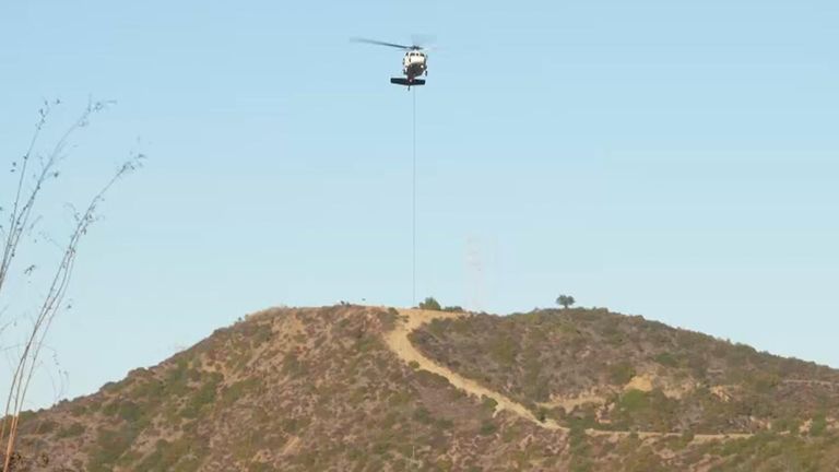 Helicopters have been dropping fire retardant to create a sodden fire break