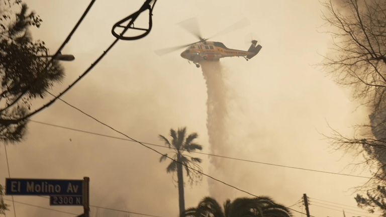 A firefighting helicopter dropped gallons of water onto burning homes in an effort to combat the blaze