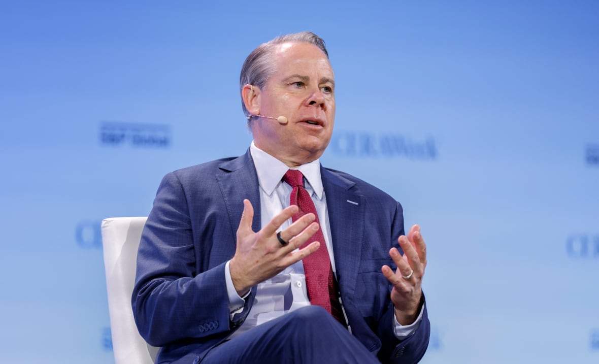 A man in a blue suit and red tie is pictured during a panel discussion at CERA Week.